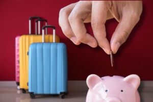 Valige e mano che mette una moneta nel salvadanaio in primo piano