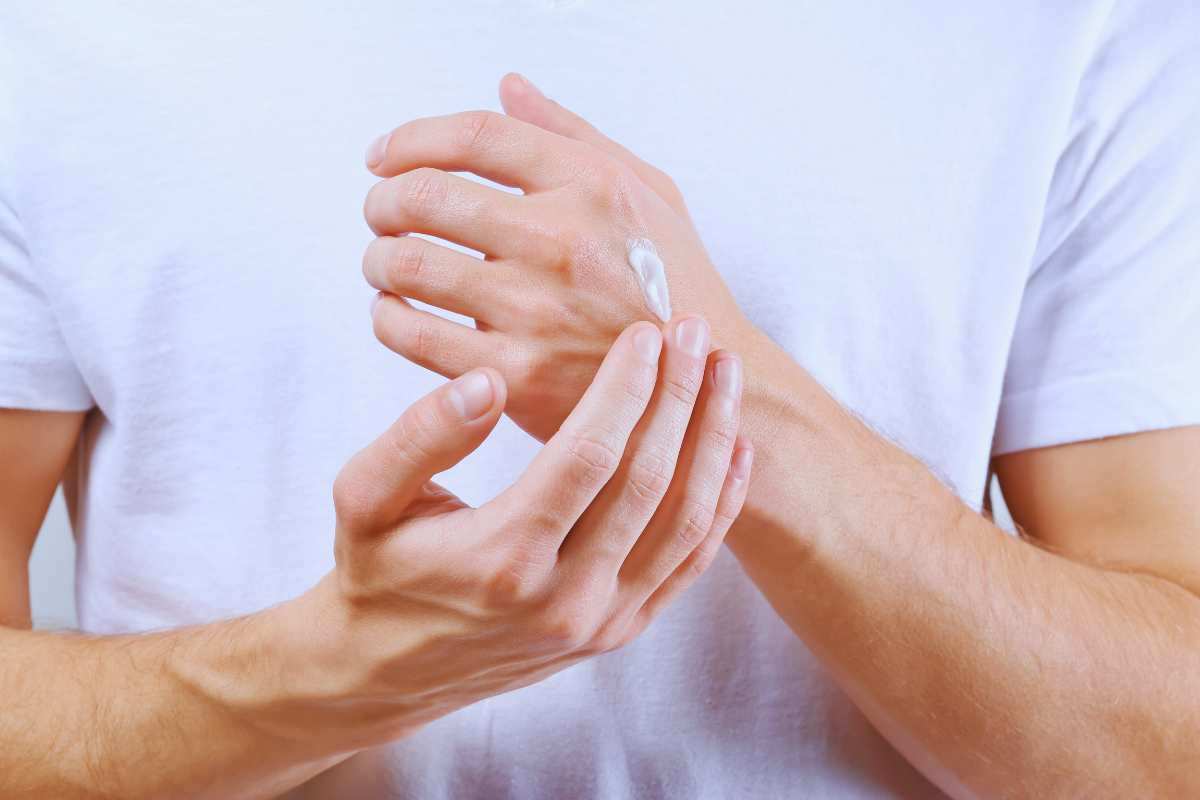 Due mani con la crema sulla pelle