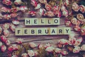 La scritta 'Hello February' con intorno tanti fiori